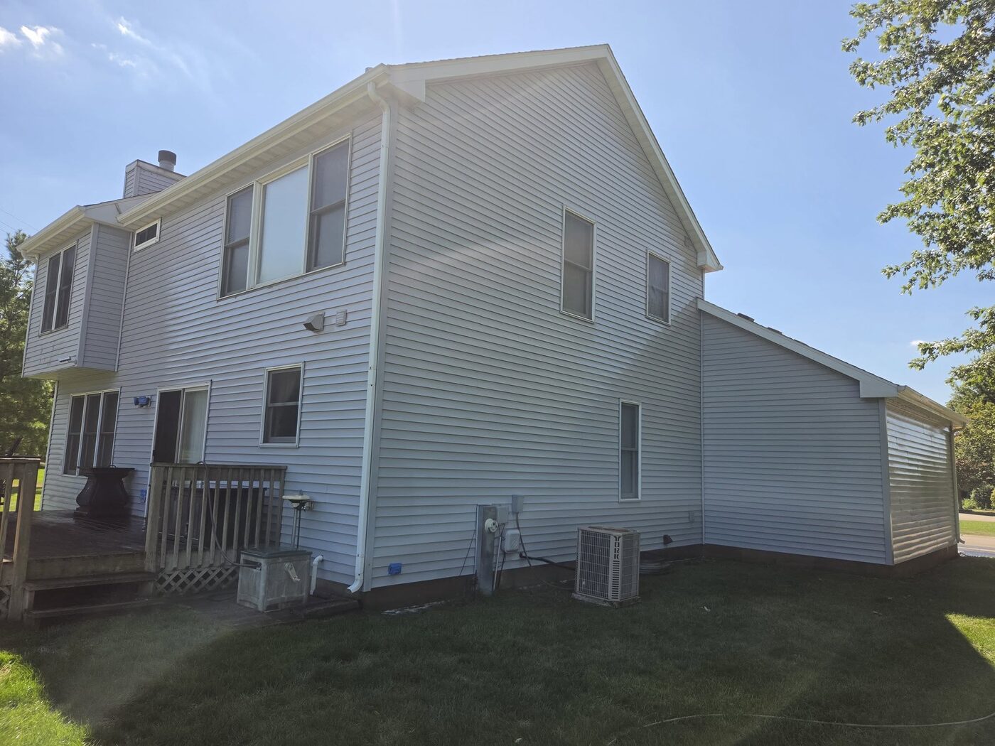 The same house after washing, the siding clean and bright in the sun