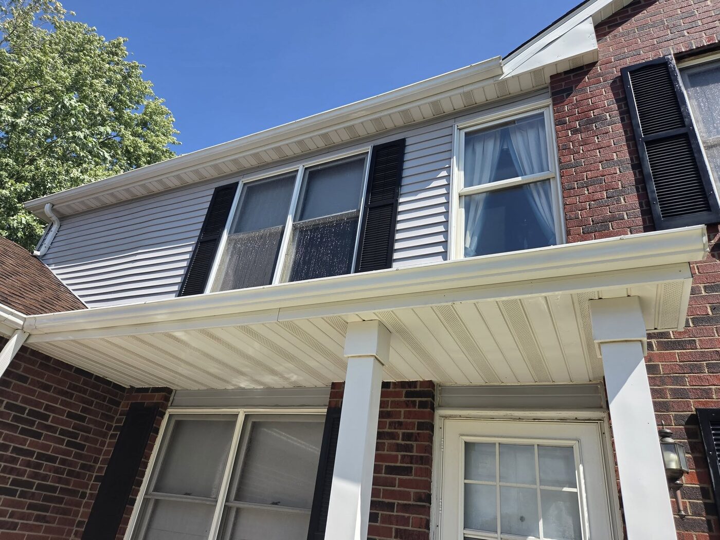 The same soffit and gutter line cleaned, the white trim bright again