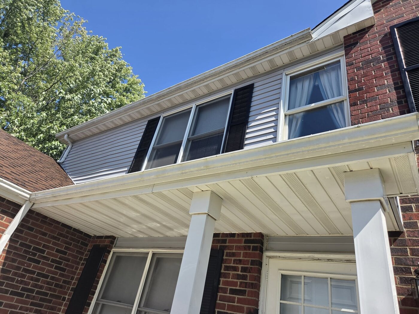 Soffit, gutter and upper siding marked with dirt before washing
