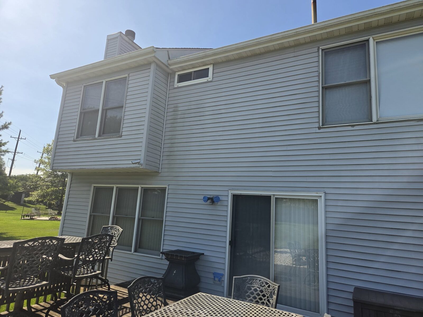The rear of a two storey home washed clean above a patio set